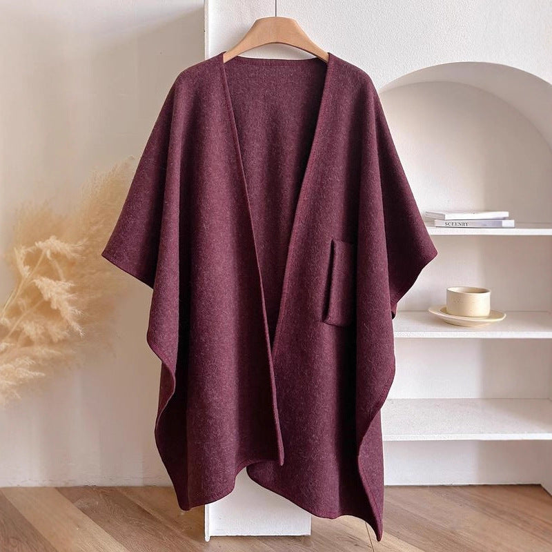Purple poncho on a hanger against a neutral background