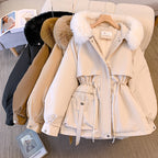 Beige winter coat with fur-lined hood on a hanger, with other coats in the background.