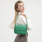 Woman holding a green handbag against a white background