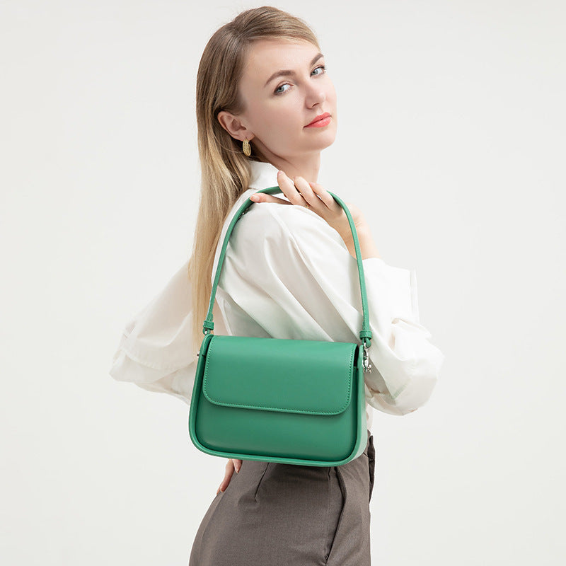 Woman holding a green handbag against a white background