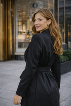 Woman in a black coat standing on a city street